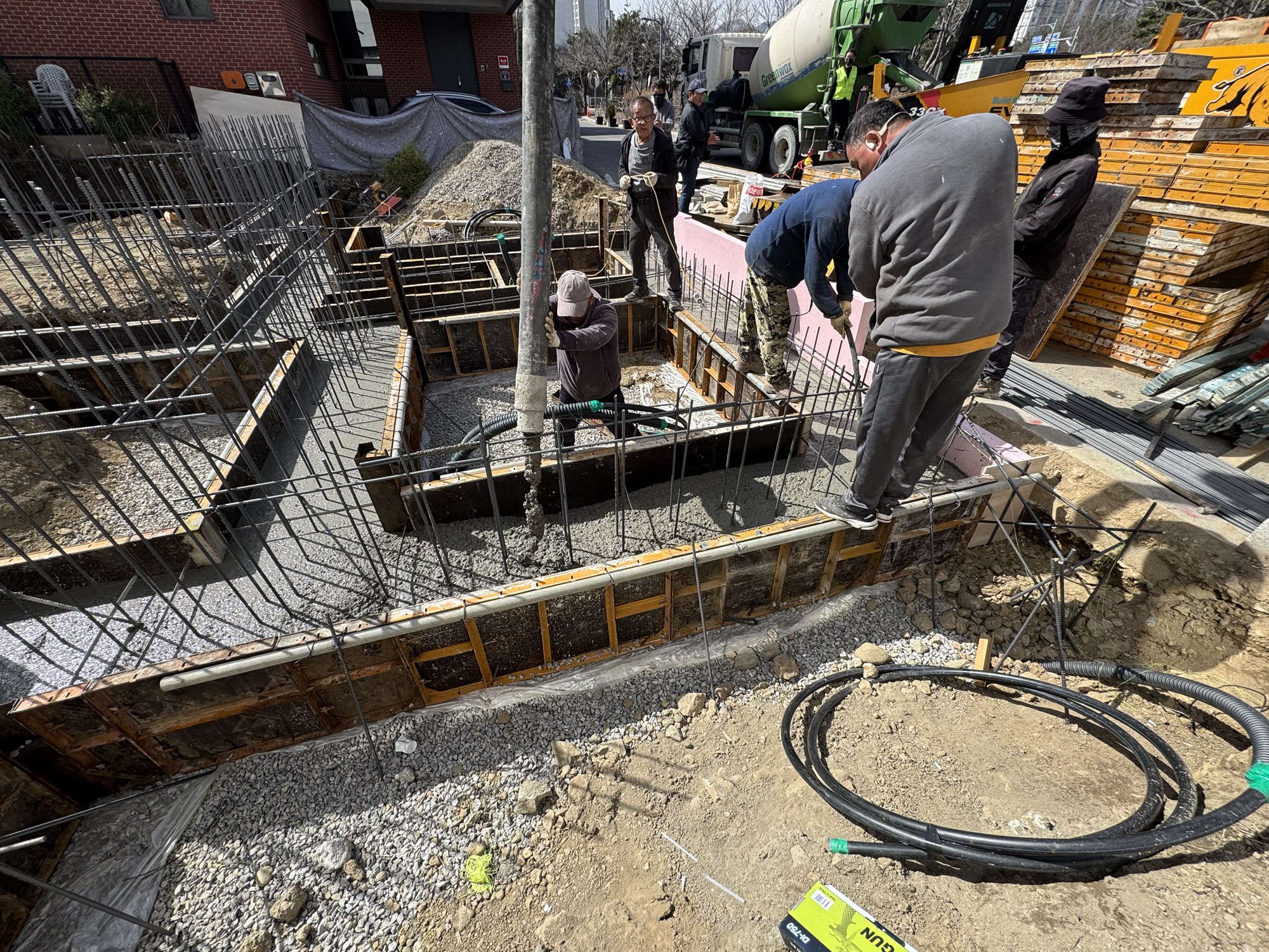 현장 작업자들이 줄기초를 위한 콘크리트를 타설하고 있는 모습.