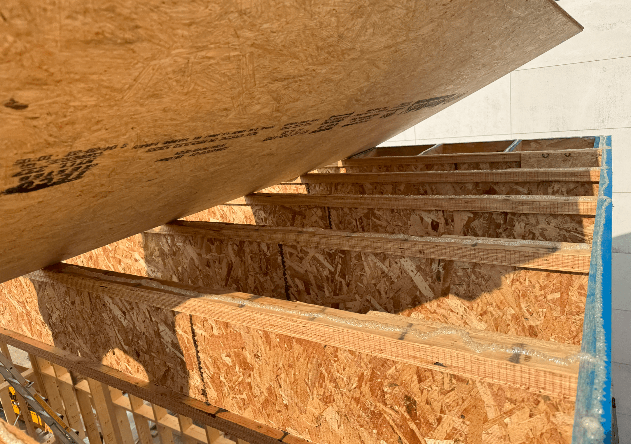 목조 구조물의 바닥 합판과 장선 간의 접합부, 구조용 접착제가 사용된 모습.