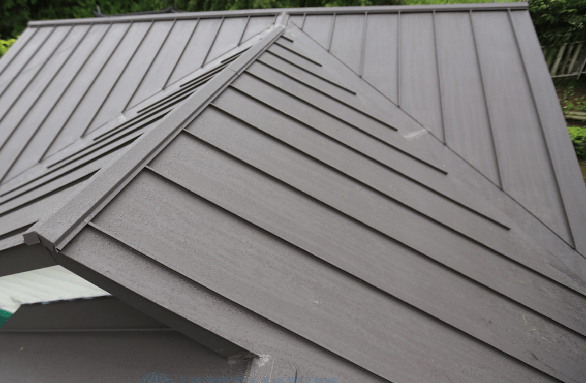 지붕의 경사면이 보여지는 이미지, 징크 재질로 보이는 세로 패널이 깔끔하게 배열되어 있으며, 물이 스며들지 않도록 설계된 구조.